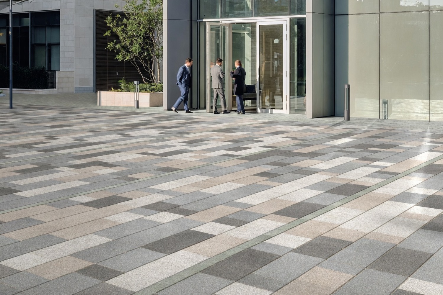 Large modular paved plaza outside a commercial office, office workers entering the building