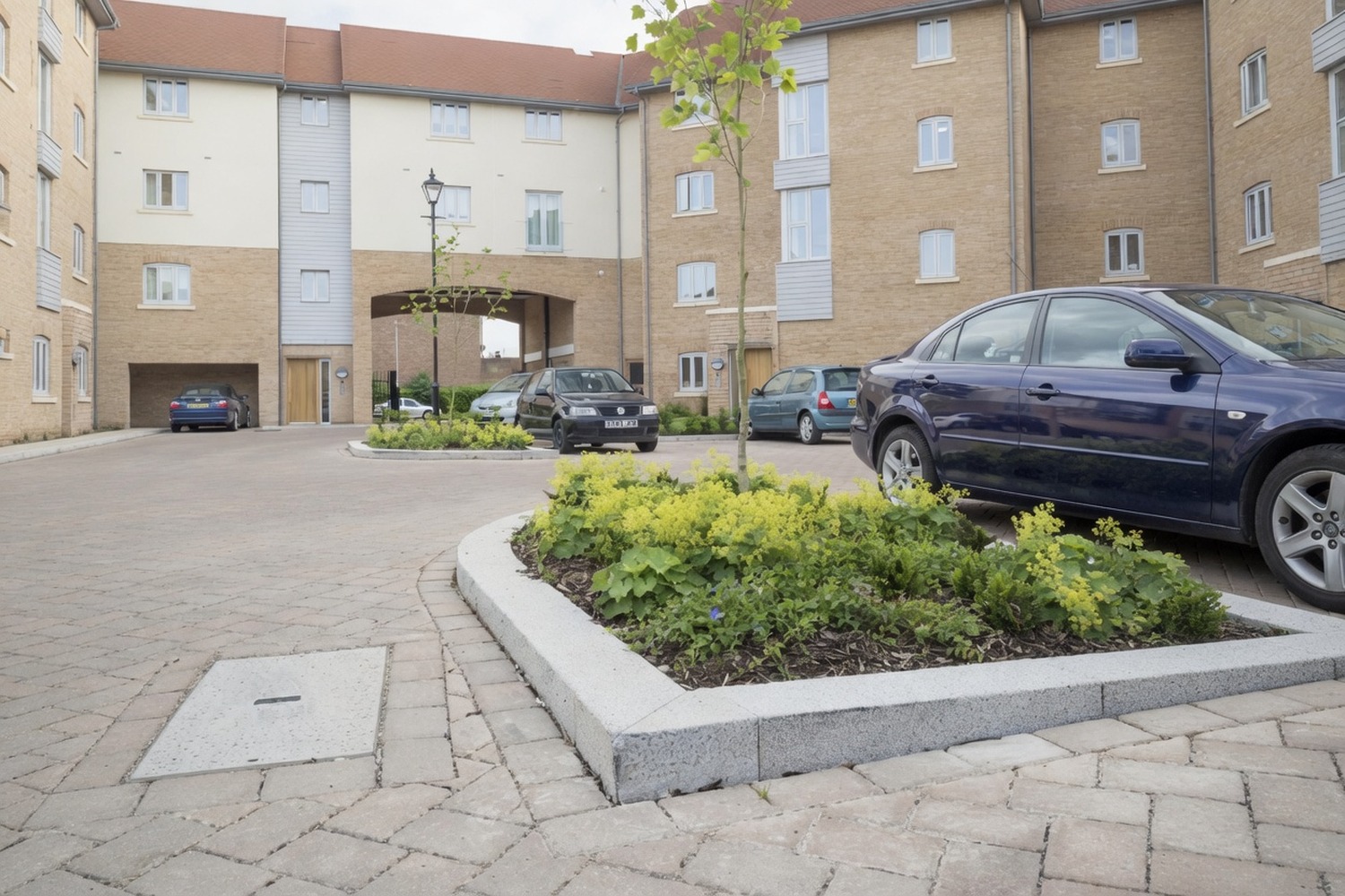 Planted flower bed integrated into a commercial car-park edge