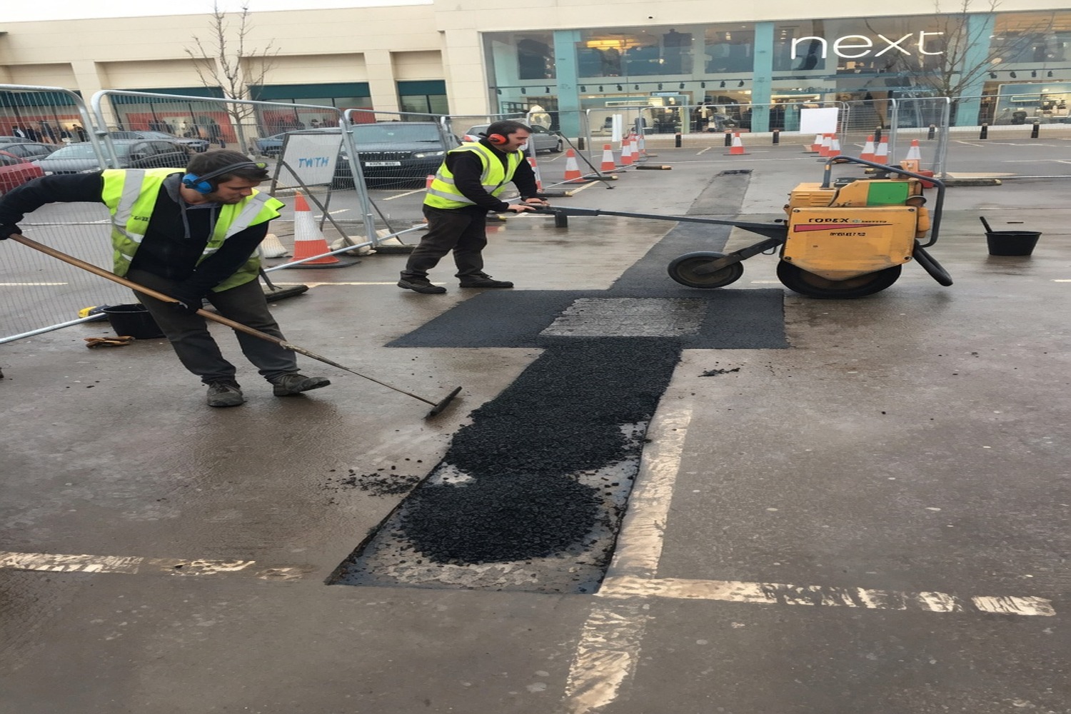 Operatives patching a failed road surface at a junction
