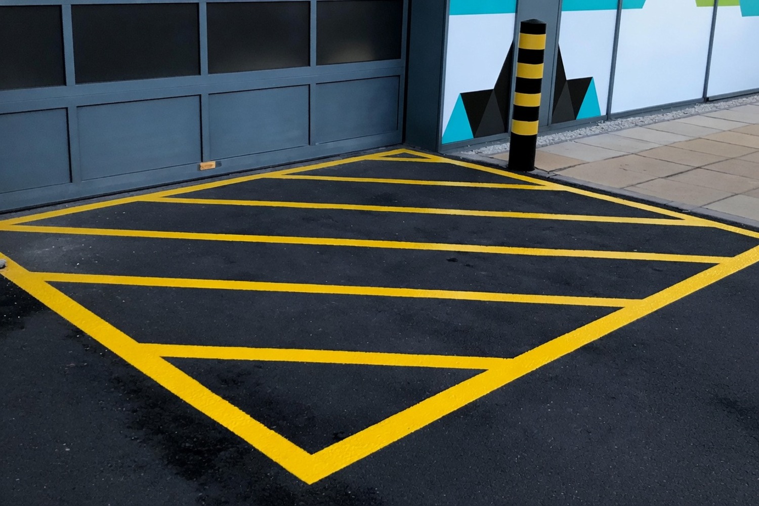 Fresh yellow hazard hatching painted across a road surface