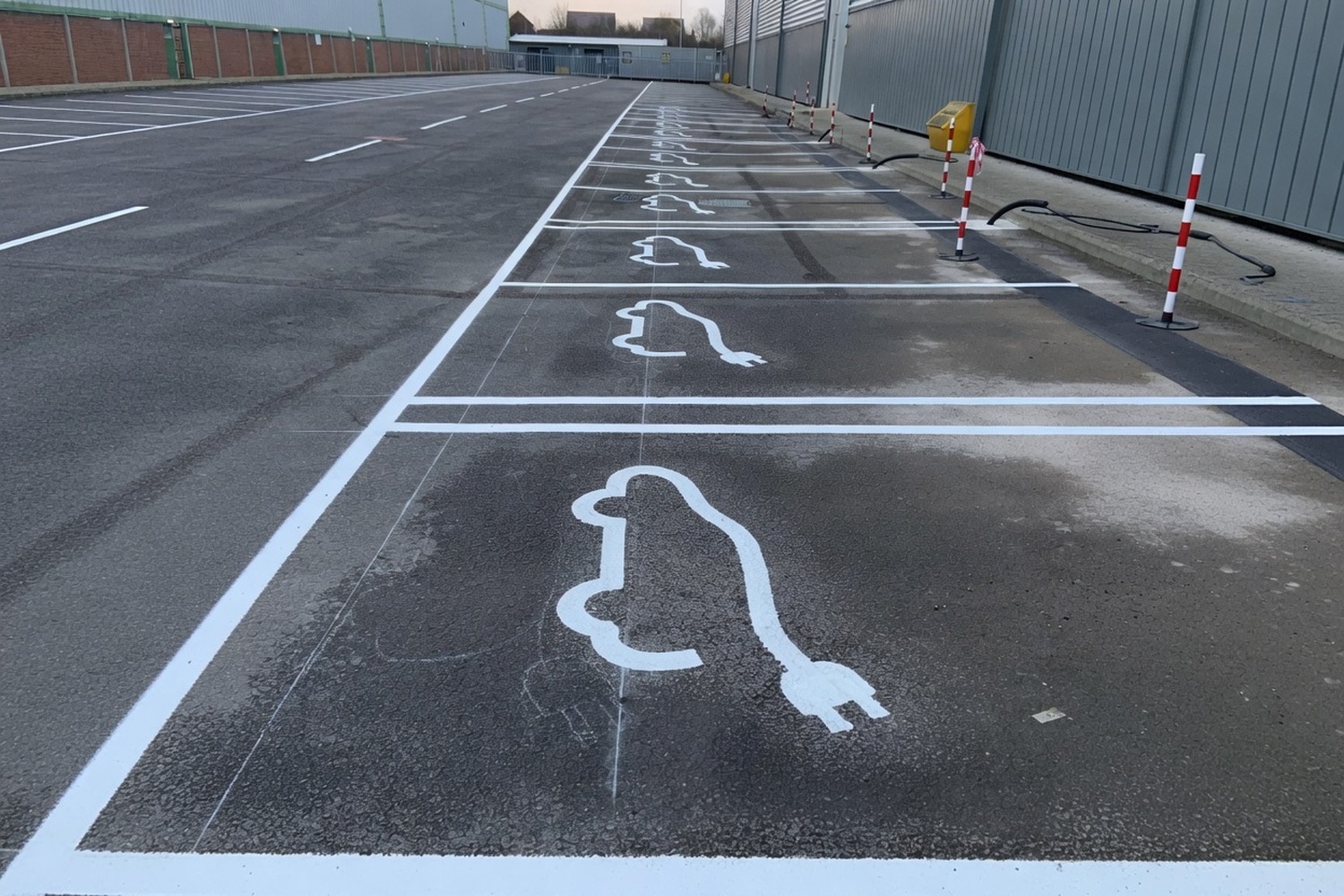 EV charging bay markings at dusk with a charging unit installed